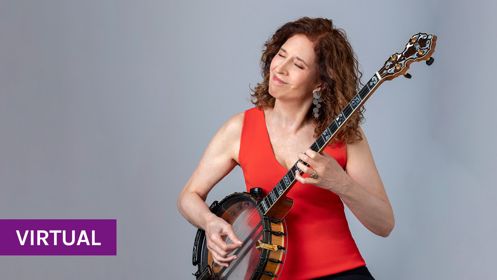 Cynthia, with a red shirt and wavy hair, plays a clear-drummed banjo with closed eyes.