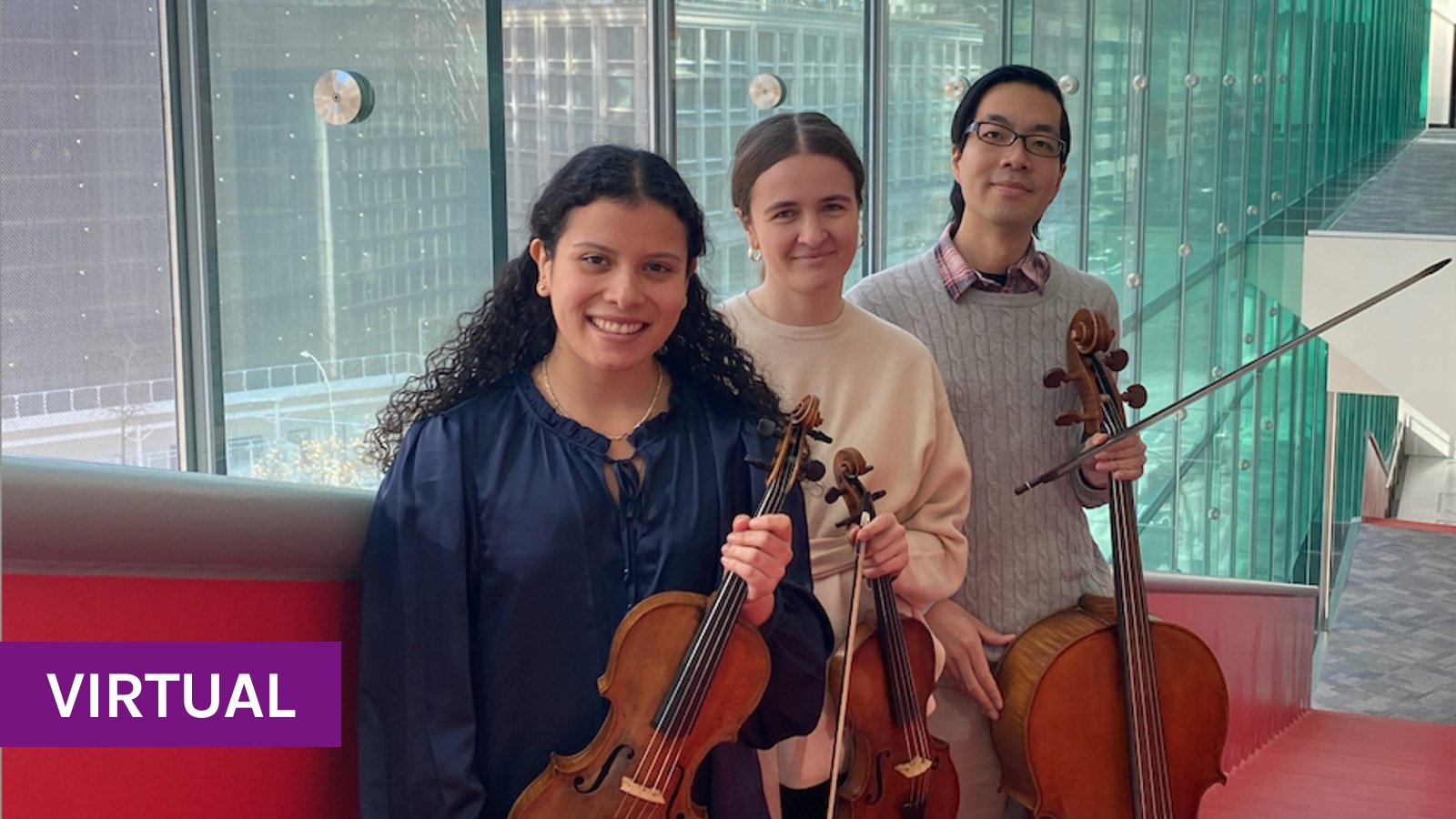 Three people smiling while holding two violins and a cello with pride. They are standing on a red staircase infront of a window with a view of  city buildings. 